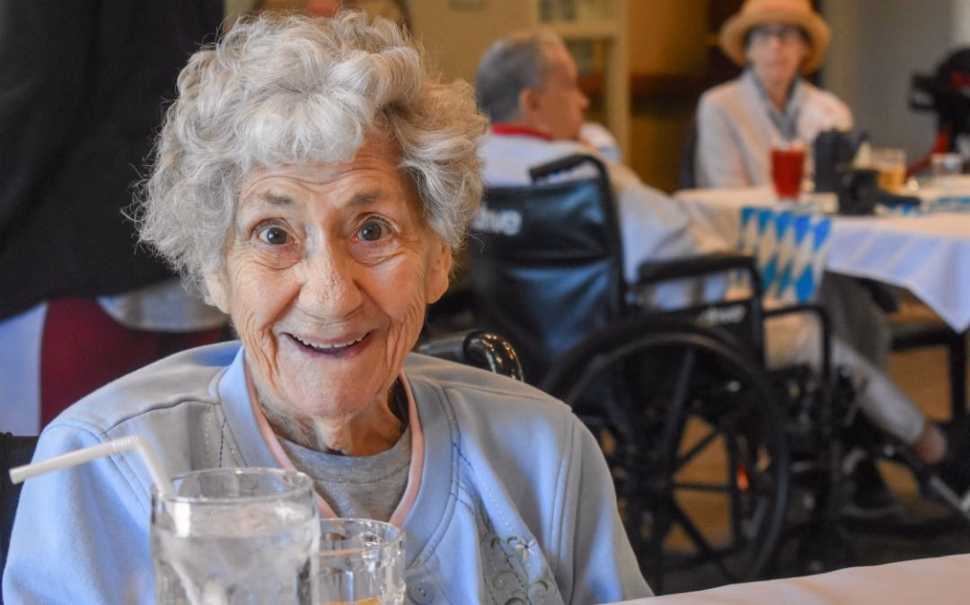 A Heritage dining resident shares a moment of joy at Willow Brook Home in Columbus, Ohio, where mealtime is a highlight of the assisted living lifestyle.